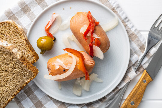Pickled sausages with onion and red pepper. Marinated food.