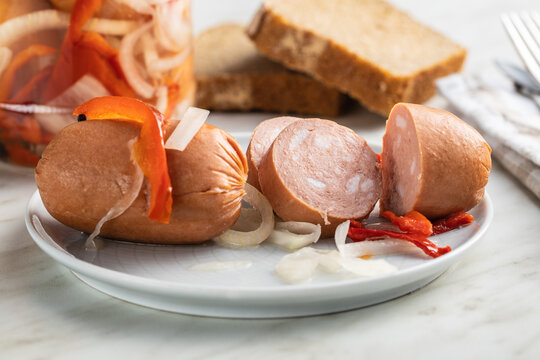 Pickled sausages with onion and red pepper. Marinated food.
