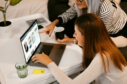 Women doing online shopping on laptop while sitting at home