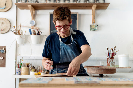 Mature female craftsperson working in ceramics store