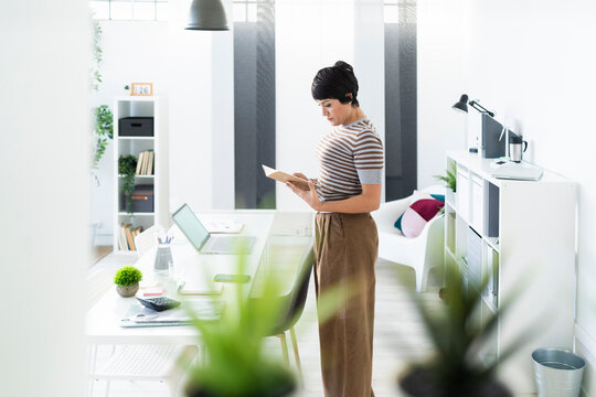 Portrait of businesswoman browsing documents in front of office table