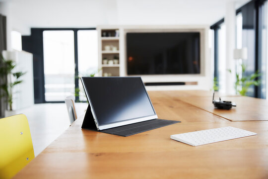 Digital tablet and white keyboard on table at home office
