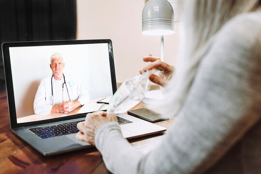Senior woman showing medical sample to doctor on video call at home