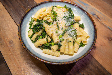 A delicious plate of Pasta with peas and herbs tops off with grated cheese.