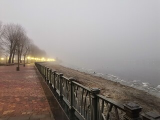Deserted winter embankment in the fog