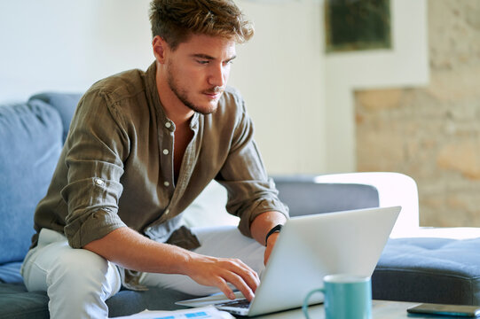 Male Freelancer Using Laptop While Working At Home