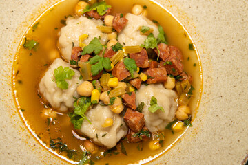 A plate of Pork Dumplings Chorizo and Sweetcorn Broth