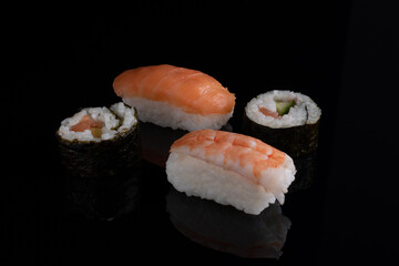 Sushi rolls and classic suchi with salmon isolated on black close up