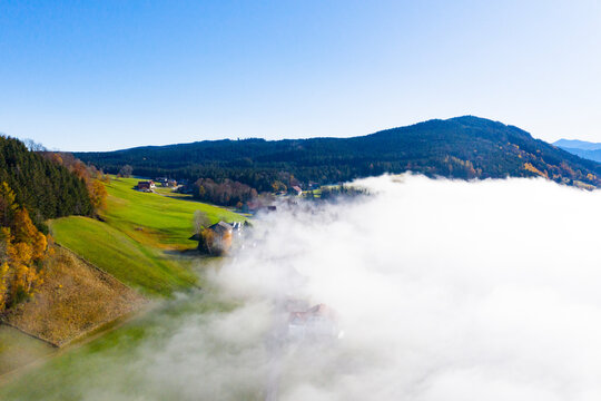 Drone view of mountain valley shrouded in thick fog