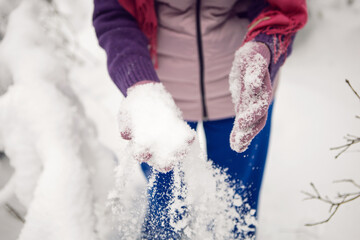 winter emotional woman in pink hat having fun in the forest with snow