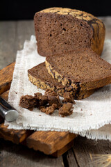 Rye bread on a serving board. Pieces of bread on a board on a wooden rustic table. Healthy rye bread