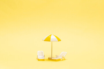 Sun lounger and yellow umbrella on a yellow background.