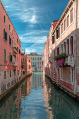 A quiet canal in Venice in sunny day with some clouds