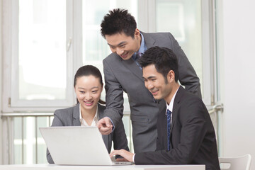 Group of businesspeople discussing working on computer