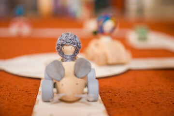 Hands of a child playing with wooden toys at home. Colorful interior of a children's room.