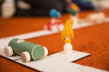 Hands of a child playing with wooden toys at home. Colorful interior of a children's room.