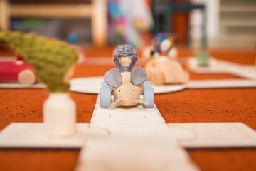 Hands of a child playing with wooden toys at home. Colorful interior of a children's room.