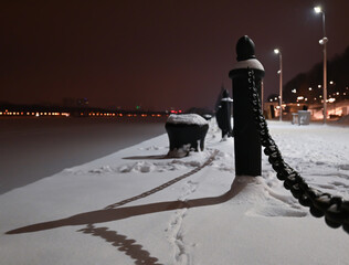 The pier fence is a large black chain. Security. Winter. Park