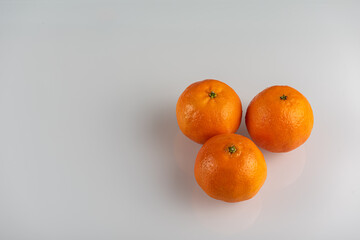 Tangerines on a light background, top view. High key. There is a place for an inscription