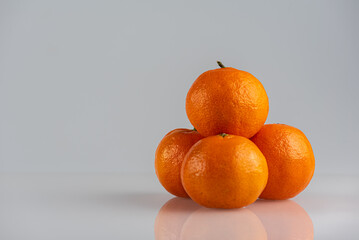 Tangerines on a light background, side view, pyramid of tangerines. High key. There is a place for...