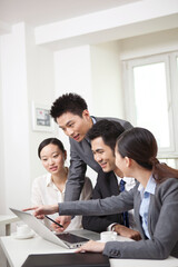 Group of businesspeople discussing working on computer