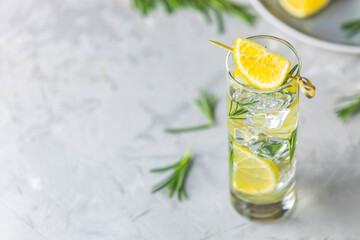 Refreshing lemon lime drink with ice cubes in glass goblets against a light gray background. Summer...