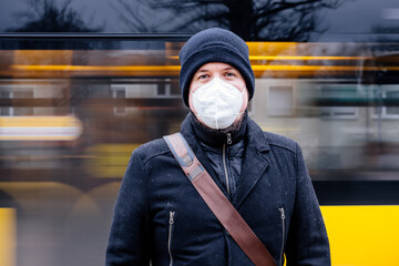 Mann mit FFP2 Maske wegen Corona Maskenpflicht im öffentlichen Nahverkehr in Deutschland Sachsen Dresden vor Haltestelle Dresdner Verkehrsbetriebe DVB - obrazy, fototapety, plakaty