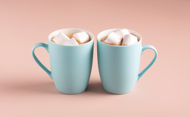Light blue mugs with coffee and marshmallows on a powdery background, horizontal orientation