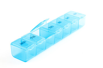 Blue plastic organizer, for pills isolated on white background. Close-up on compartments pill case with clip lids medicine. Daily vitamins and supplements dosage routine concept.