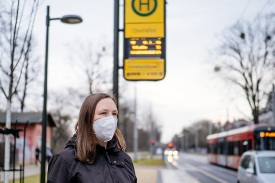 Frau mit FFP2 Maske wegen versch&auml;rfter Corona Maskenpflicht im &ouml;ffentlichen Nahverkehr in Deutschland Sachsen Dresden vor Haltestelle Dresdner Verkehrsbetriebe DVB