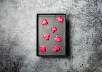 Gray paper box with heart shaped pink sweets