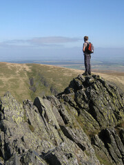 Obraz premium Hiker on precarious Sharp Edge on way to Blencathra, Lake District