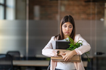 Business lady fired. The global economic crisis. Job cuts due to company bankruptcy. Portrait of Caucasian sad businesswoman standing in office with box of stuff. Leaving business.