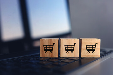 Wooden cube with shopping cart on laptop keyboard. Online Shopping concept