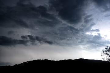 Strong lightning in and behind big towering thunderclouds