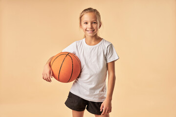 Cheerful girl basketball player holding game ball