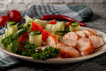 Fried homemade sausage with fresh vegetables on a platter