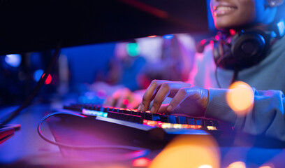 Professional cyber video gamer African American woman keyboard for stream in neon color blur background © Parilov