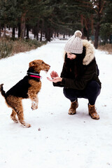 Woman giving snow to her dog