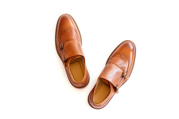 A pair of light brown double monk strap shoes isolated on white background. Versatile business casual dress shoes without laces. Top view, copy space for text, flat lay.