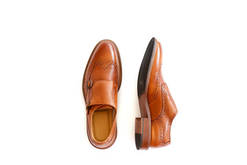 A pair of light brown double monk strap shoes isolated on white background. Versatile business casual dress shoes without laces. Top view, copy space for text, flat lay.