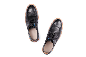 A pair of black patent leather oxford shoes isolated on white background. Versatile business casual dress wingtip. Top view, copy space for text, flat lay.