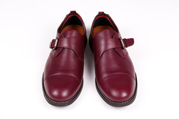 A pair of burgundy single monk strap shoes isolated on white background. Versatile business casual dress shoes without laces. Top view, copy space for text, flat lay.