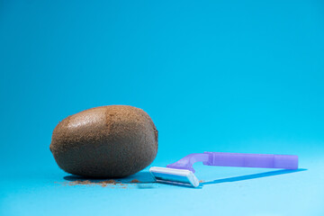 Shaved kiwi with razor on blue background