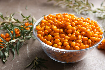 Ripe sea buckthorn berries on marble table, closeup