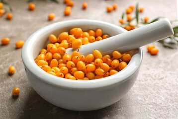 Ripe sea buckthorn berries on marble table, closeup