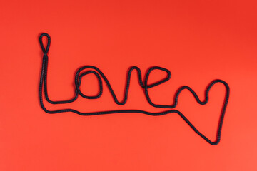 Flat lay of word love on bright red background.