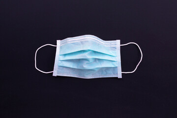 Protective medical mask on dark background. Top view