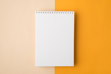 Above overhead close up view photo of clear notebook document with spiral lying isolated over half yellow and beige backdrop