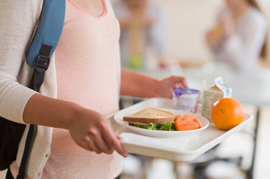 Female student carrying tray in cafeteria